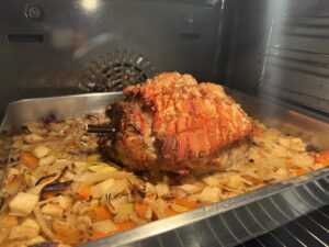 Krustenbraten mit knuspriger Schwarte auf Gemüsebett im Ofen